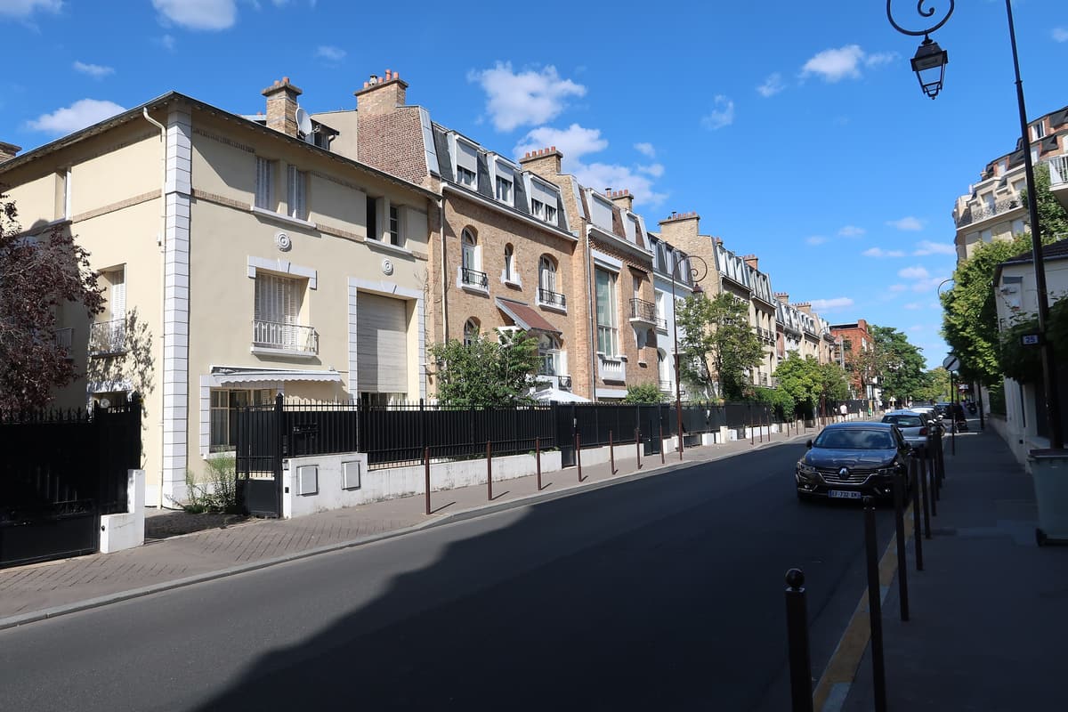 Rue du Bois-de-Boulogne : une rangée de maisons de ville en brique et en enduit clair, lucarnes dans les toits, murets et grilles noires le long du trottoir.